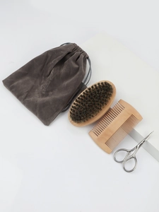 Detailed view of a 4-piece men beard grooming kit with wooden brushes and steel scissors