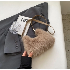 Detail of plush khaki faux fur shoulder bag with adjustable brown leather strap