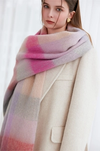 Close-up of thick pastel plaid scarf featuring soft pink, purple and grey fringe tassels
