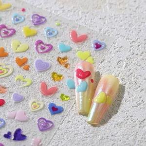Macro view of colorful 3D heart nail art stickers on iridescent yellow nails