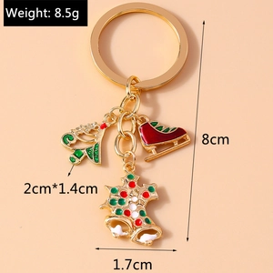 Detail of Christmas keychain with enamel tree and bell charms including size labels