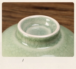 Macro view of Chinese ceramic pedestal plate with light green ice crackle glaze and texture