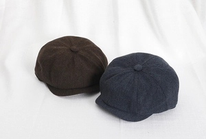 Dettaglio dei cappelli newsboy in tweed a spina di pesce in marrone scuro e blu navy