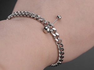 Close-up of silver steel beaded bracelet with T-bar clasp on a person's wrist