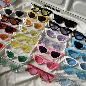 Flat lay of colorful cat eye sunglasses in various jelly colors on white fabric