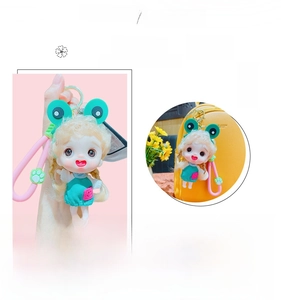 Detail of cute doll keychain with frog hat shown on bag and in hand, 80-100 characters