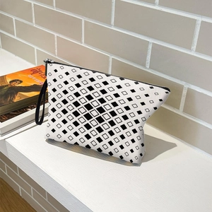 Portable checkered makeup bag with black and white geometric pattern and wristlet strap