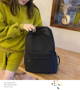 Detail of minimalist black backpack featuring matte fabric and silver U-shaped zipper puller
