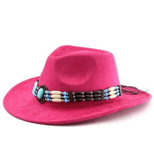 Detail of rose red suede cowboy hat featuring ethnic turquoise and beaded hatband trim