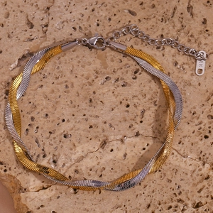 Detail of two-tone braided blade chain anklet with 18K gold plating and lobster clasp