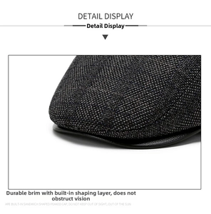 Detailed close-up of dark grey woven wool flat cap with sturdy visor and inner lining