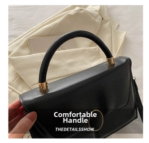 Détail du sac à main noir minimaliste montrant le cuir lisse et les finitions dorées