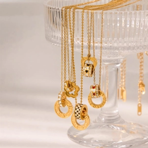 Detalle de collar de acero de titanio dorado con grabado LOVE y colgante de corazón