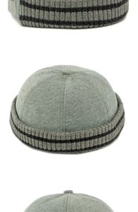 Detailansicht der dunkelgrauen Strickmütze mit schwarzen Streifen und stoffbezogenem Knopf
