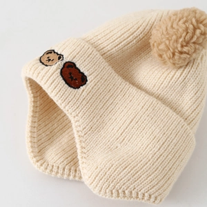 Bonnet d'hiver en tricot beige pour bébé avec pompon et broderie d'ours