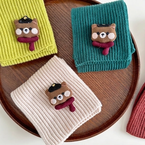 Cute knitted children's scarves with cartoon bear patches in green and beige colors