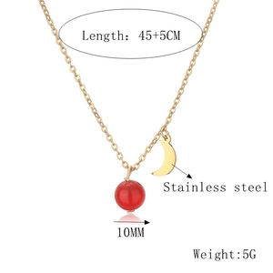 Détail d'un collier en acier inoxydable doré de 45+5cm avec pendentif lune et pierre rouge