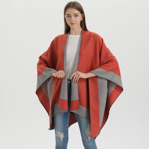 Detail of red and grey patchwork knit poncho shawl showing loose fit and soft fabric texture