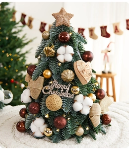Detailed close-up of a mini desktop Christmas tree with gold baubles and star topper