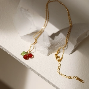 Elegant K18 gold plated necklace with red carnelian cherry pendant on white stone base