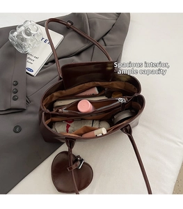 Interior view of large brown tote bag showing multi-compartment storage and heart charm