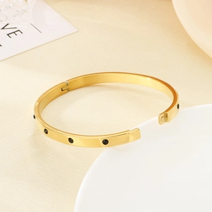 Minimalist gold stainless steel hinged bangle featuring set black round stones