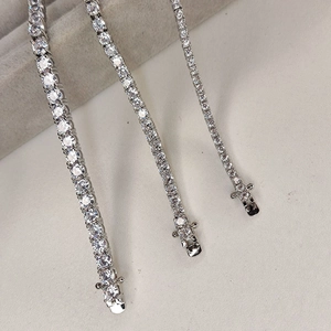 Detailed comparison of three silver tennis chain sizes with zircon stones in jewelry box