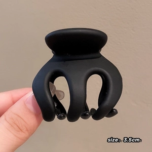 Macro shot of 3.5cm matte black claw clip showing smooth texture and compact size