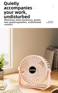 Pink portable desktop USB fan on a wooden desk with a keyboard and plants