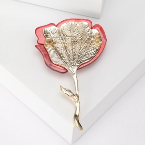 Detailweergave van de achterkant van de roosbroche met goudkleurige veertextuur en speld