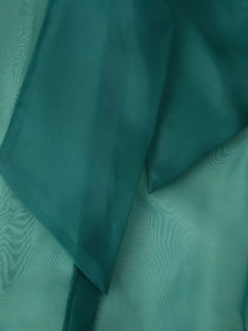 Detail-Makroansicht der dunkelgrünen Organza-Stofftextur und plissierten Chiffon-Lagen