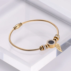 Gold wire bangle with crystal pavé disc and hanging angel wing charm in stainless steel
