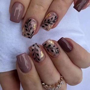 Short press-on nails with pink and burgundy colors, floral leaf patterns and gold foil