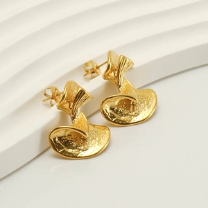 Macro view of 18k gold plated earrings featuring a hand-hammered texture and petal design