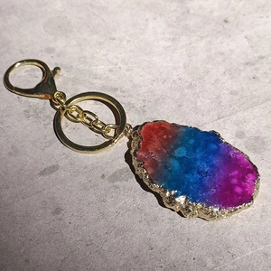 Macro detail of natural agate stone keychain with golden trim and gradient crystal texture