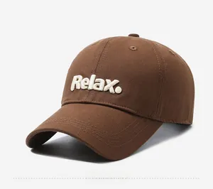 Detailed close-up of 3D white Relax embroidery on a dark brown cotton baseball cap