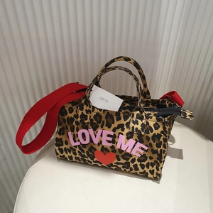 Detailed shot of leopard print tote bag with pink LOVE ME print and red shoulder strap