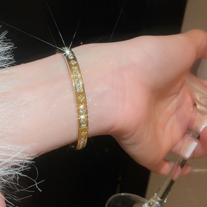 Detail of a gold-plated bangle featuring sparkling zircons and starburst engravings