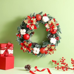 Détail de couronne de Noël avec poinsettias, coton, pommes de pin et paillettes dorées