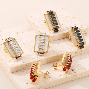 Macro shot of rectangular gold titanium earrings with black, red and white zircon stones
