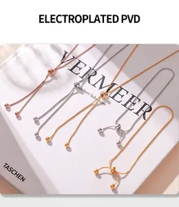 Detail view of 18K gold plated bead necklaces with adjustable PVD slide clasp on book