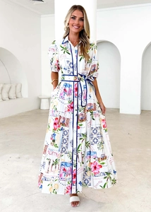 Detailansicht des tropischen Blumendrucks und Italien-Schriftzug auf weißem Kleid