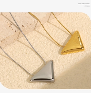 Detailed close-up of gold and silver triangle pendants on high-quality snake chains