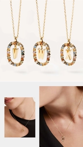 Detailed macro view of oval crystal letter pendants V, W, X in gold-plated settings