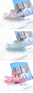 Detailed macro of pearlescent acrylic hair claws in lavender, mint, and peach colors
