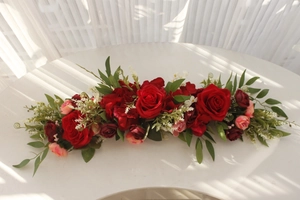 Detailed view of red artificial rose flower row on a table for wedding decor
