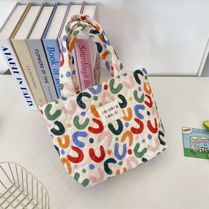Détail du sac fourre-tout matelassé avec motifs en U colorés et étiquette de marque