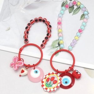 Detailed view of colorful evil eye beaded keychains with butterfly and flower charms