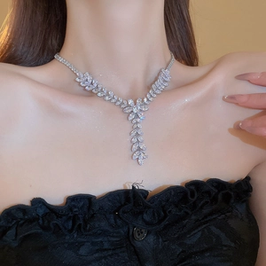 Close-up of silver-plated wheat ear necklace with sparkling zircon tassels on a model