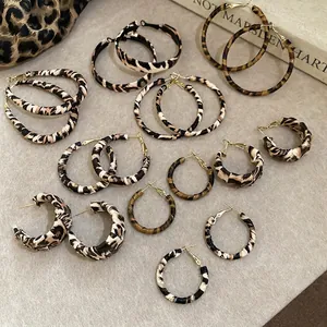 Retro leopard print hoop earrings with gold metal accents on a stylish background